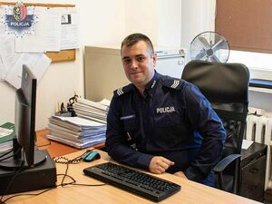 Policjant, którzy siedzi przy biurku w pokoju służbowym