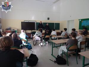 dwóch policjantów w sali lekcyjnej z uczniami