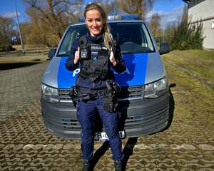 Policjantka stoi przed radiowozem