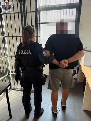 policjantka z mężczyzną w kajdankach